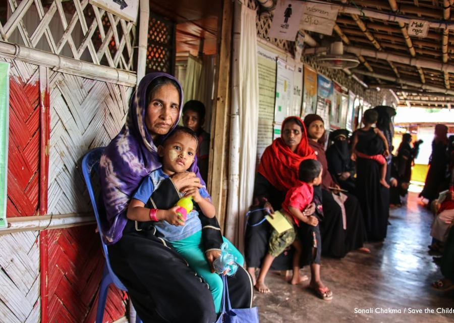 Donna Rohingya tiene in braccio suo figlio seduta in un tendone del campo profughi cox s bazar