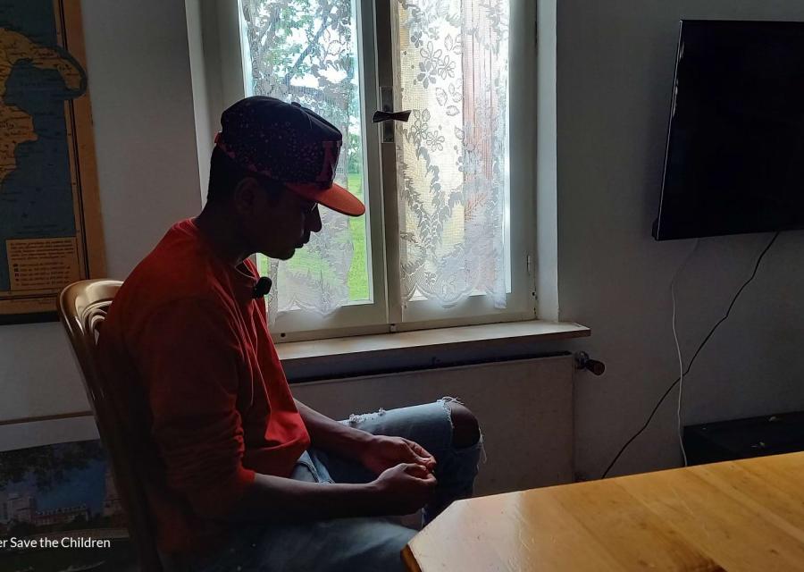 minore migrante di profilo seduto