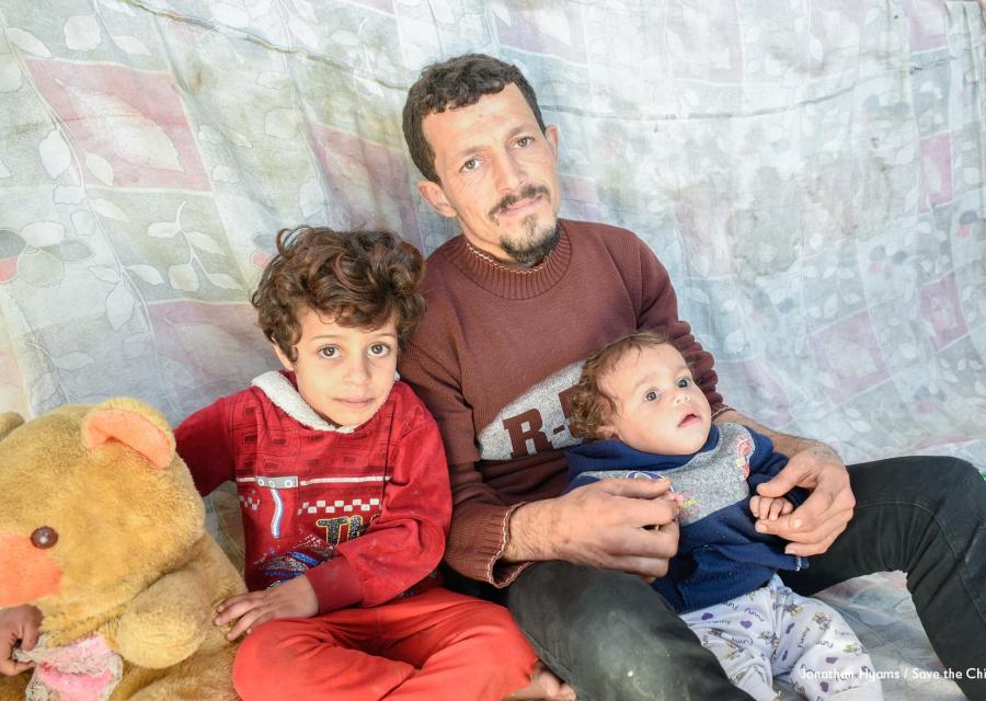 Un padre con i due figli, uno seduto accanto a lui, l altro più piccolo è in braccio a lui.