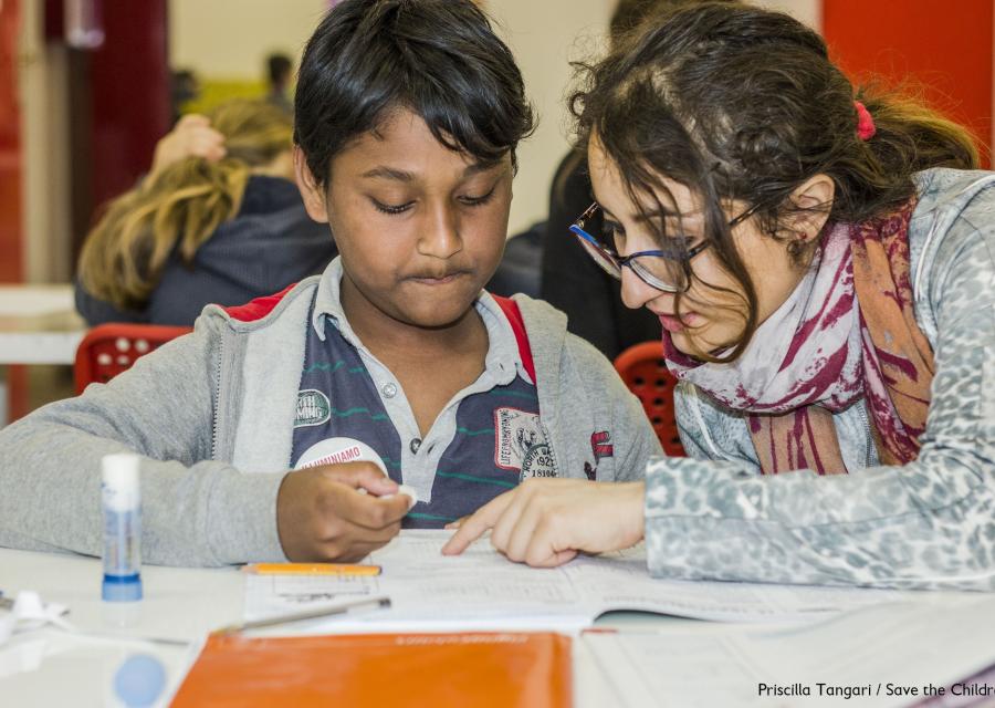 due ragazzi seduti a un banco di scuola fanno i compiti insieme