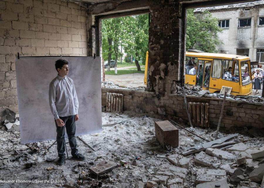 guerra in Ucraina ragazzo in stanza distrutta dai bombardamenti che guarda fuori 