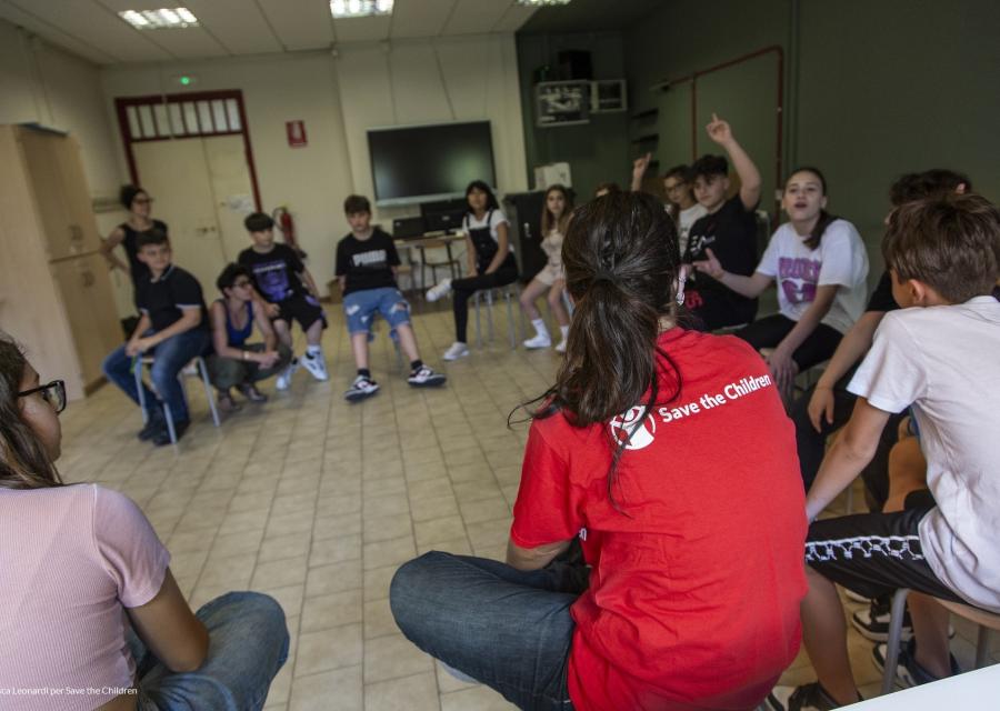 ragazzi e ragazzi che partecipano ad attività scolastiche con operatrice save the children 