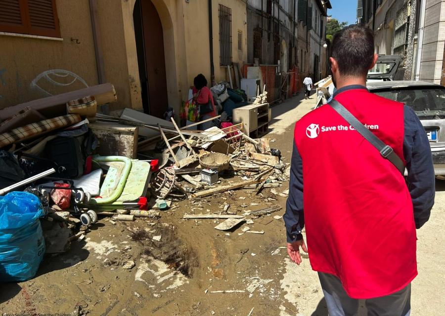 Operatore Save the Children dall'alluvione in Emilia Romagna cammina vicino a casa con fango