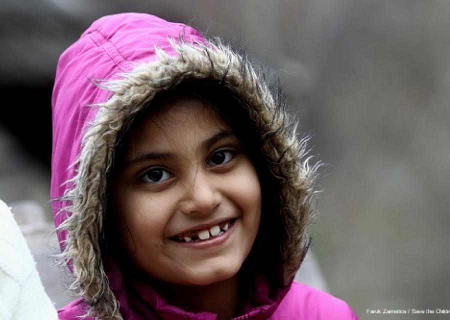 bambina con cappotto rosa e cappuccio che ride