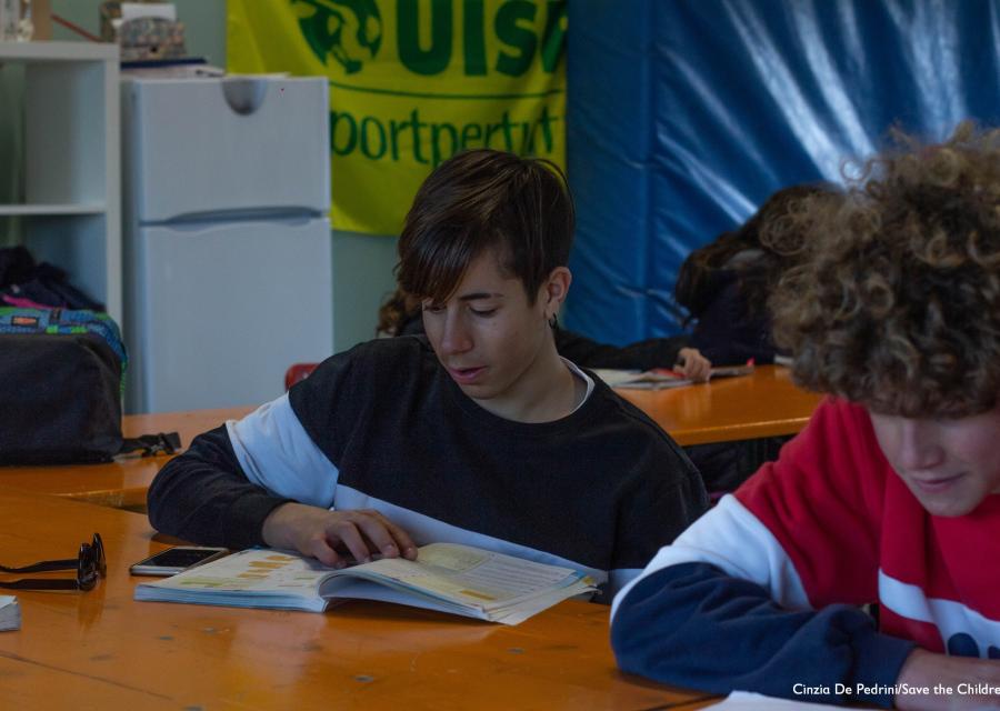 due ragazzi seduti a un banco in un aula di un punto luce stanno facendo i compiti di scuola