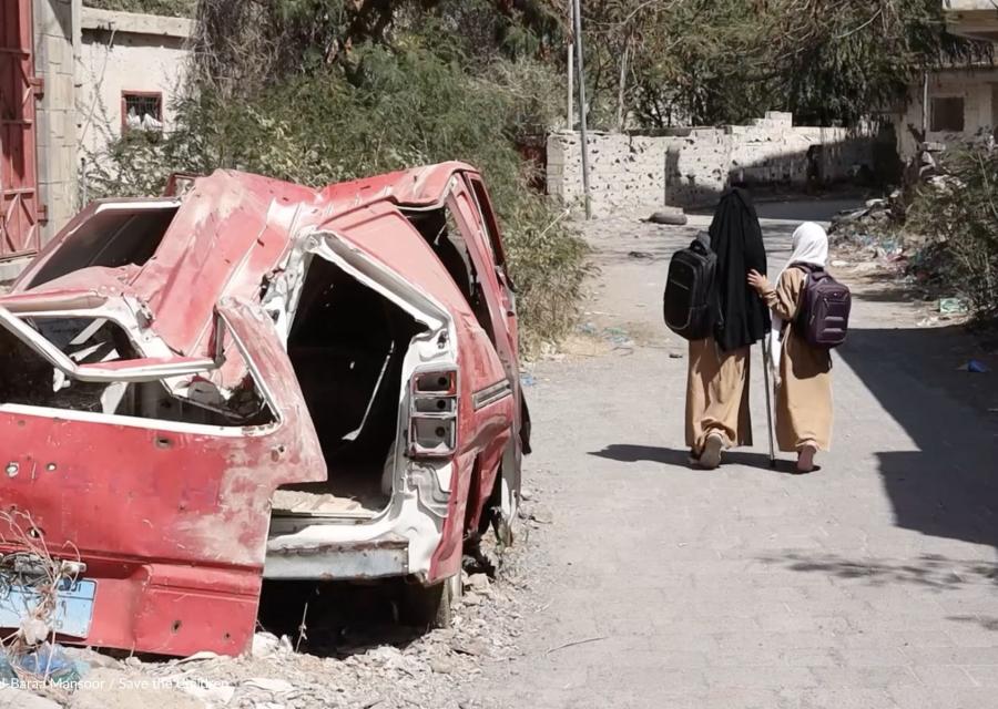 bambine in Yemen che camminano per strada a sinistra macchina distrutta