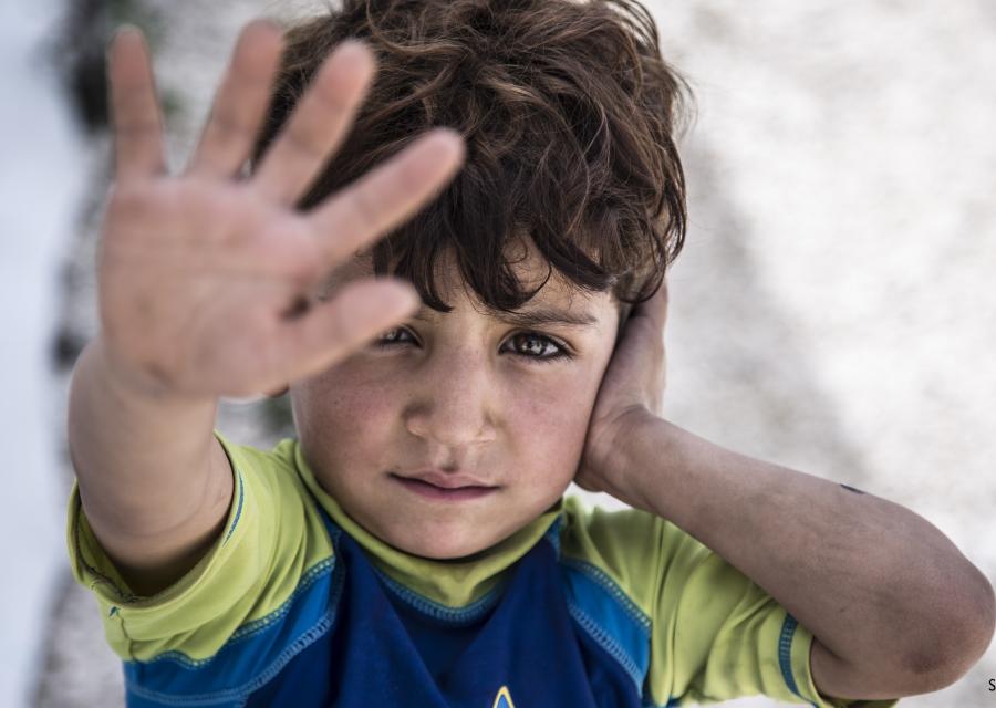 primo piano bambino libanese con mano in primo piano aperta davanti al volto