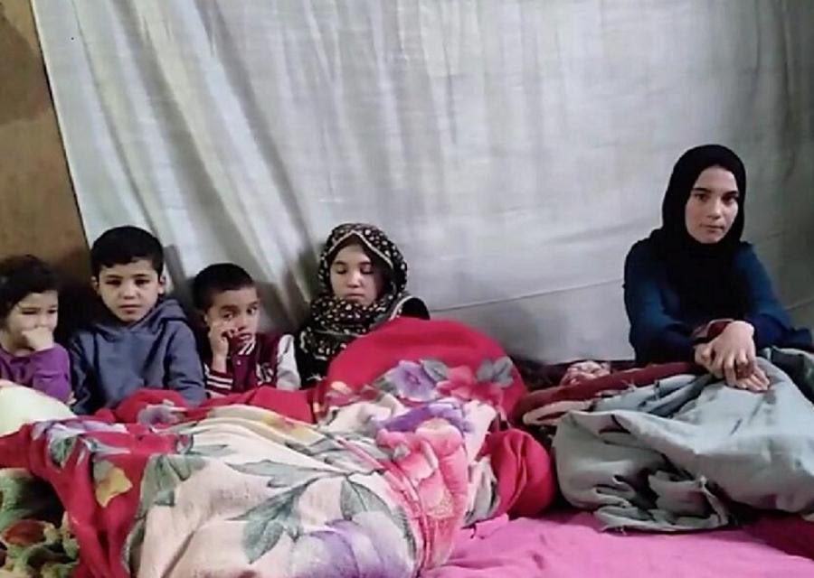 Famiglia libanese che si scalda sotto a una coperta