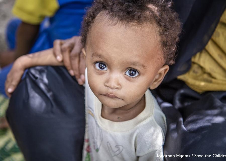 Primo piano di un bambino yemenita tra le gambe di un adulto