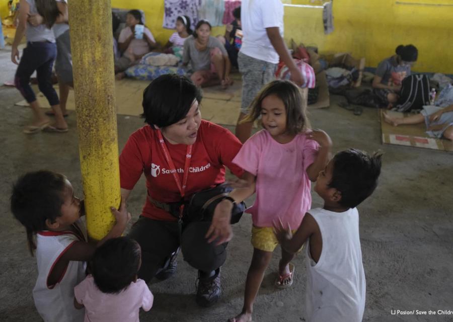 Operatrice save the children parla con bambini in spazio a misura di bambino allestito nelle Filippine per emergenza eruzioni vulcano Taal