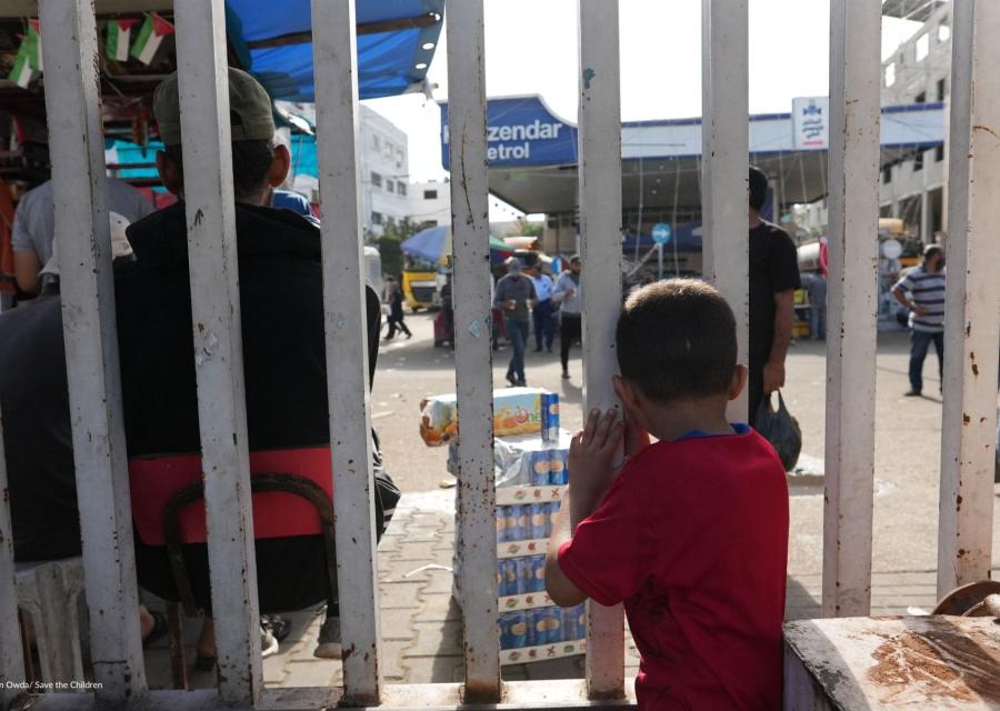 Bambino a Gaza che guarda oltre delle sbarre