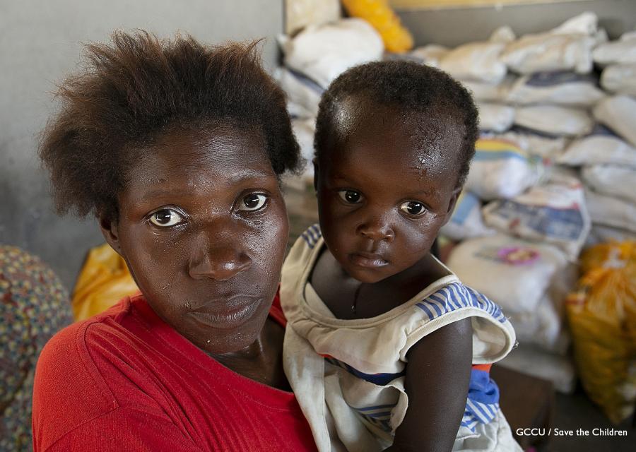 Primo piano di mamma e figlio di origine mozambicana. Il bambino è in braccio alla donna.