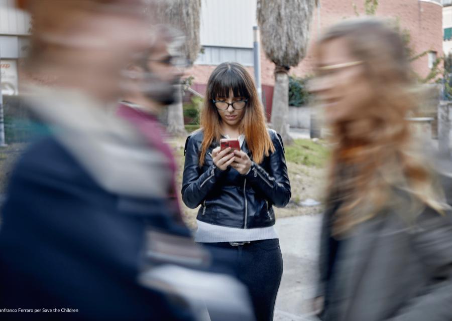 ragazza con cellulare in mano passeggia distratta 