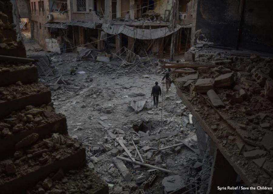 foto dall alto di un quartiere in Siria bombardato, nel sentro un uomo che cammina