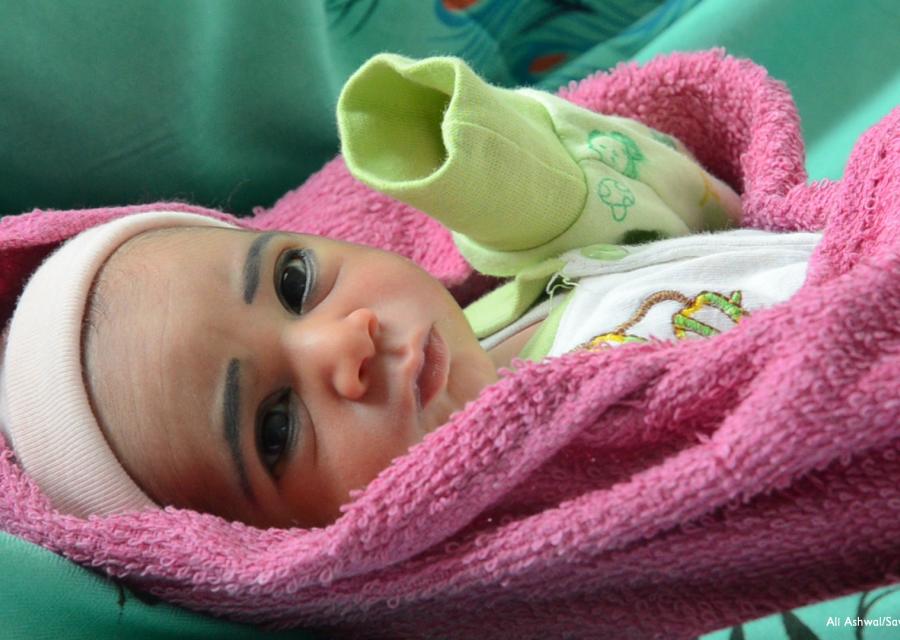 Neonata yemenita nel lettino con coperte colorate
