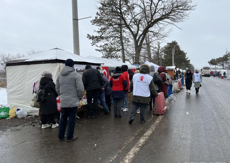 strada, neve, persone che si avvicinano a uno stand di save the children per ricevere degli aiuti