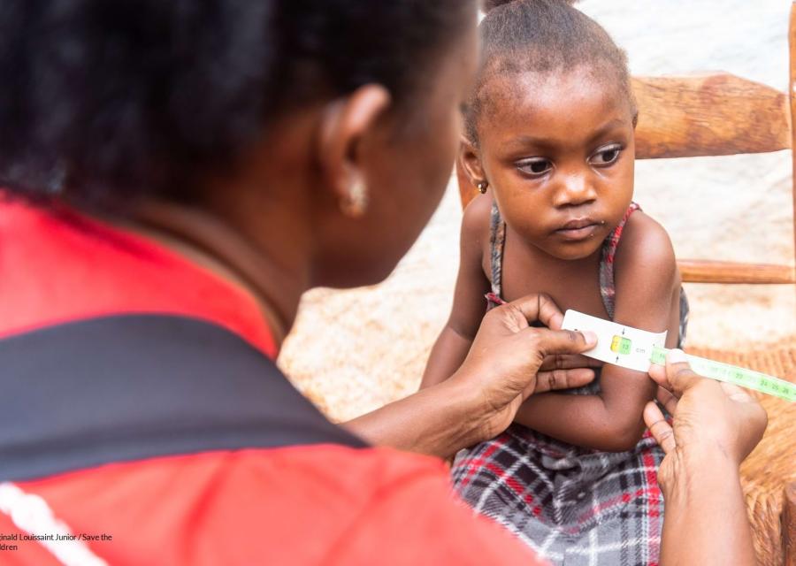 staff save the children con una bambina di Haiti