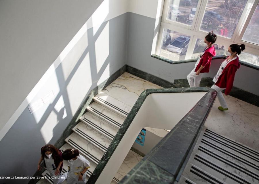 scala di un ospedale con dottori/esse che scendono 