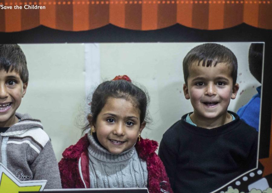2 bambini e una bambina dietro una sagoma di cartone che simula lo schermo di un cinema