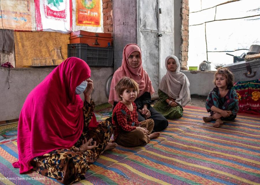 bambini afghani seduti su una stuoia 
