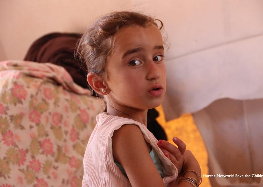 bambina di profilo si gira sorpresa. Indossa un vestitino smanicato rosa, ha i capelli castani e legati.
