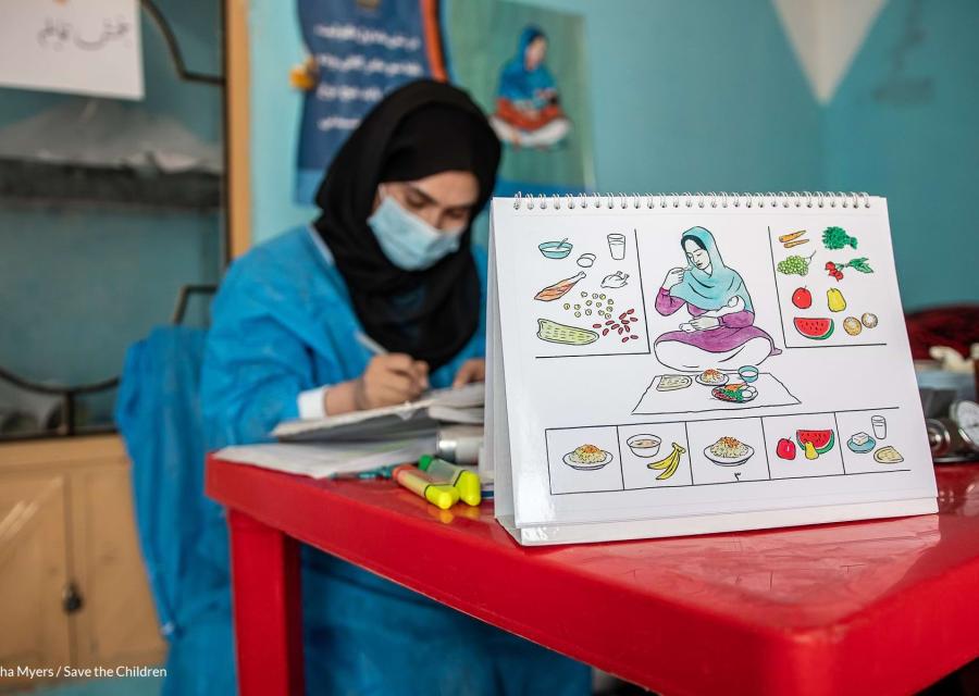 operatrice sanitaria save the children seduta a un tavolo scrive 