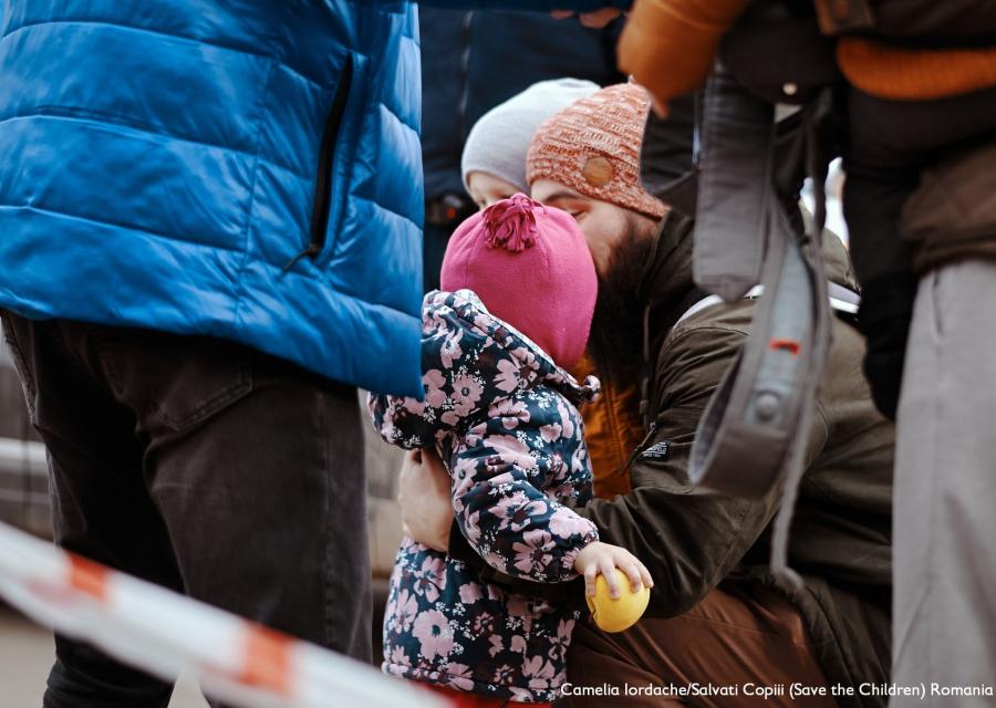 una bimba e il suo papà abbracciati in mezzo ad altre persone