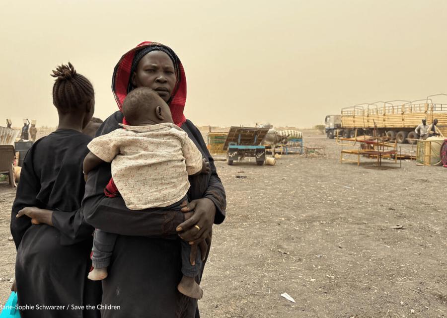 terreno arido in sudan con madre che tiene in braccio il figlio 