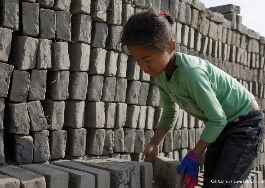 Bambina nepalese sposta mattoni in una fornace di fabbricazione