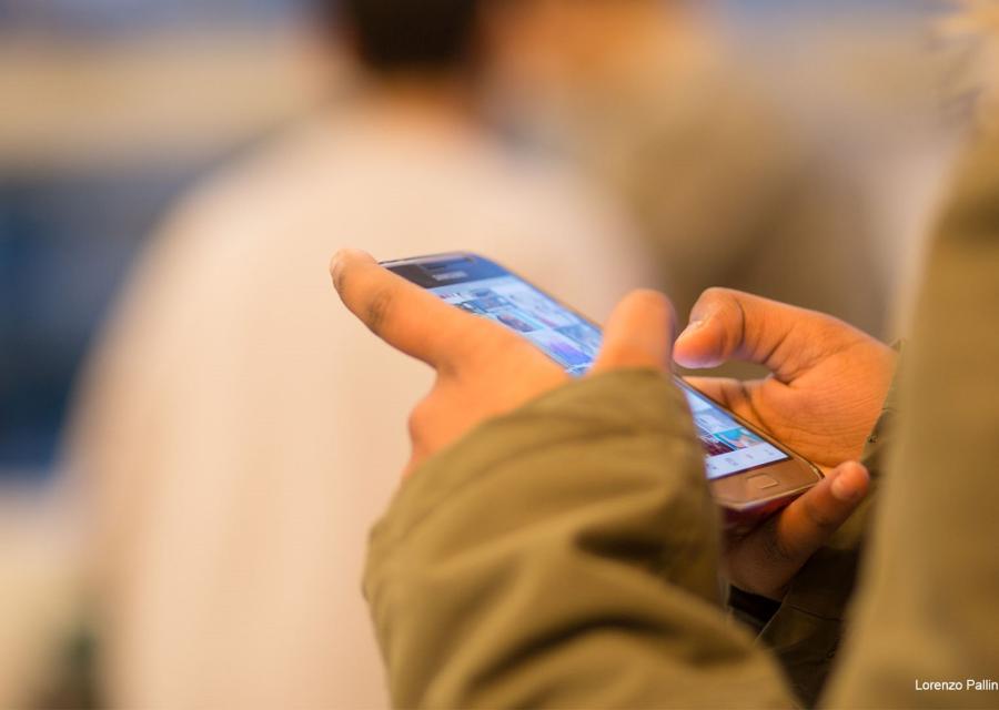 Primo piano delle mani di un bambino che giocano con cellulare 
