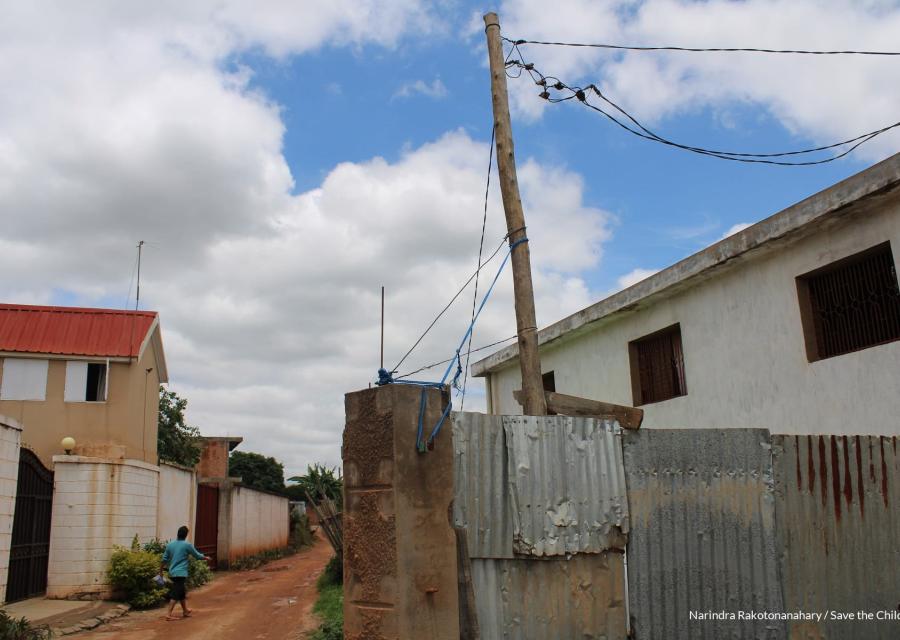 case in lamiera del Madagascar colpite dal cilone batsirai e strade infangate, una donna di spalle con maglia celeste cammina