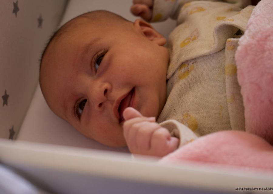 Neonato nella culla primissimo piano sorride