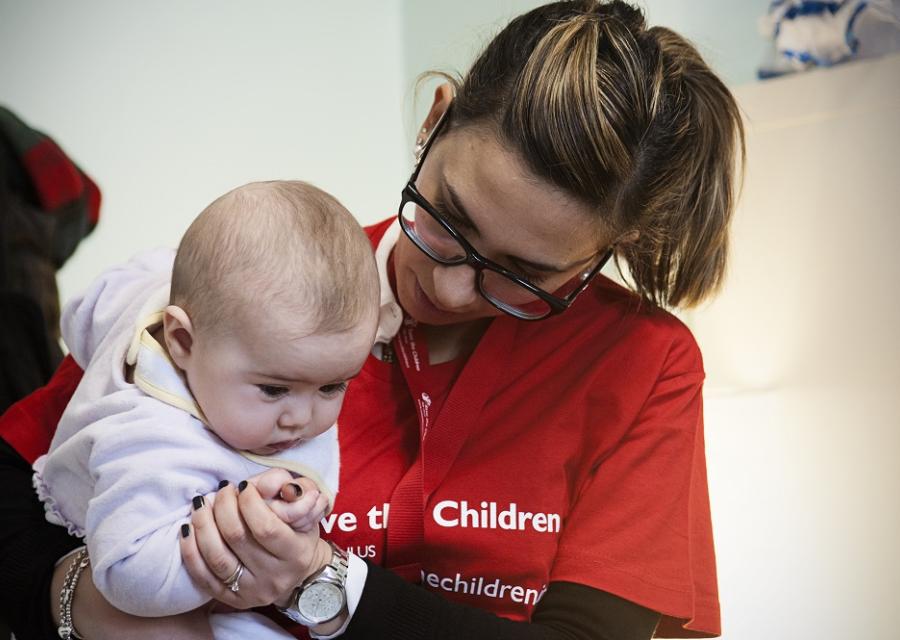 operatrice-save-the-children-guarda-neonata-in-braccio