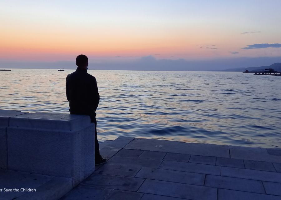 uomo di spalle guarda l'orizzonte sul mare