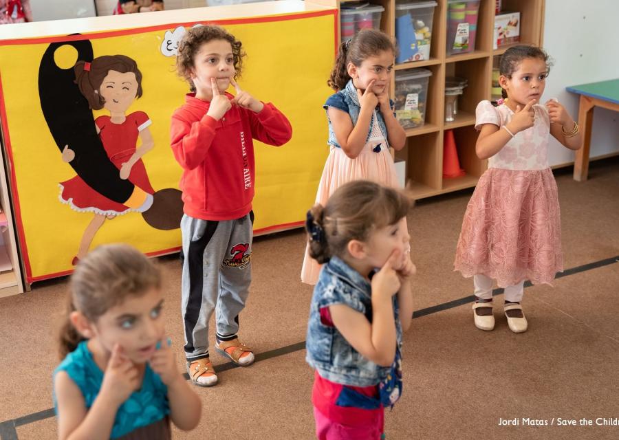 5 bambine giocano in piedi all'interno di un asilo nel campo di zaatari in Giordania