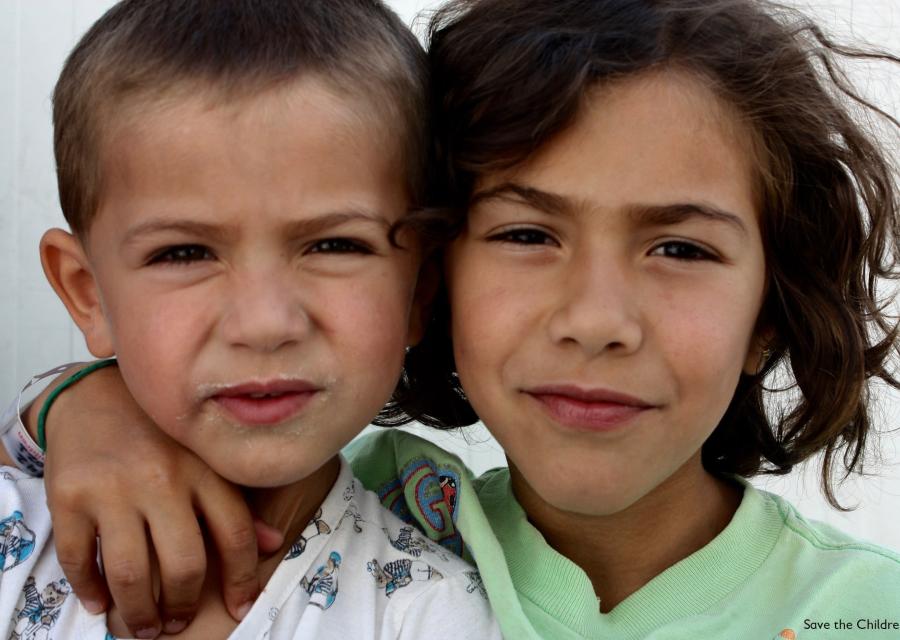 due bambini in primo piano, uno con i capelli corti l altro lunghi, uno con il braccio sulla spalla dell altro