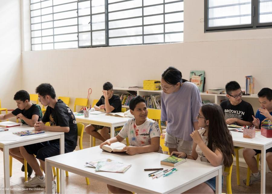 studenti e studentesse seduti tra i banchi di scuola