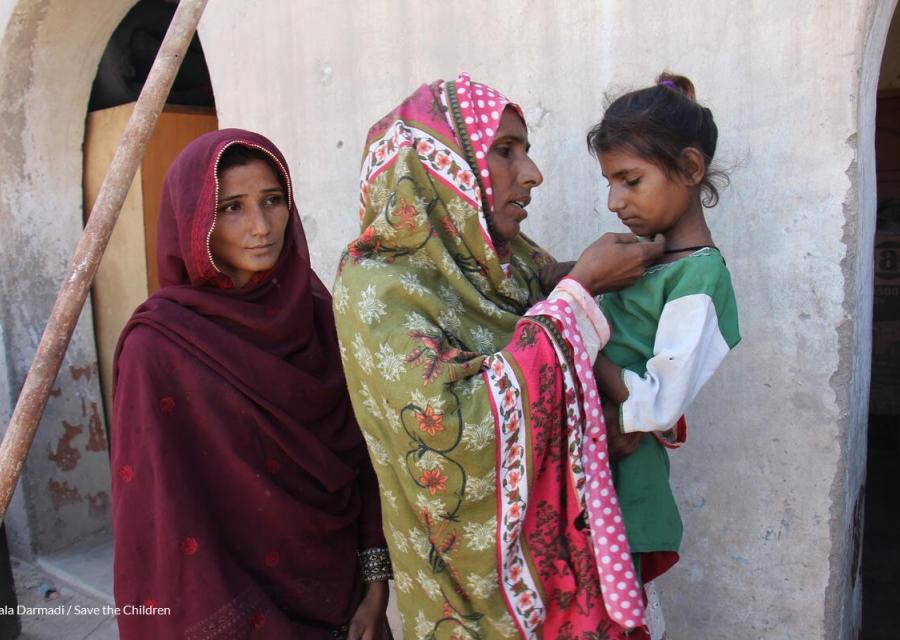 donne pakistane con veli colorati. a sinistra ragazza, al centro la madre con in braccio la figlia minore triste