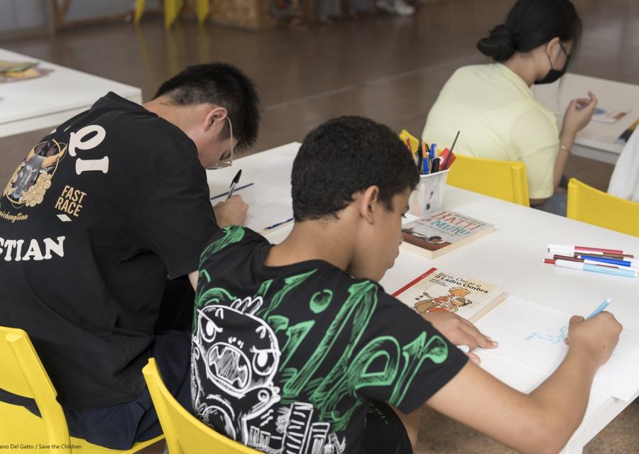 due ragazzi che scrivono su un banco 