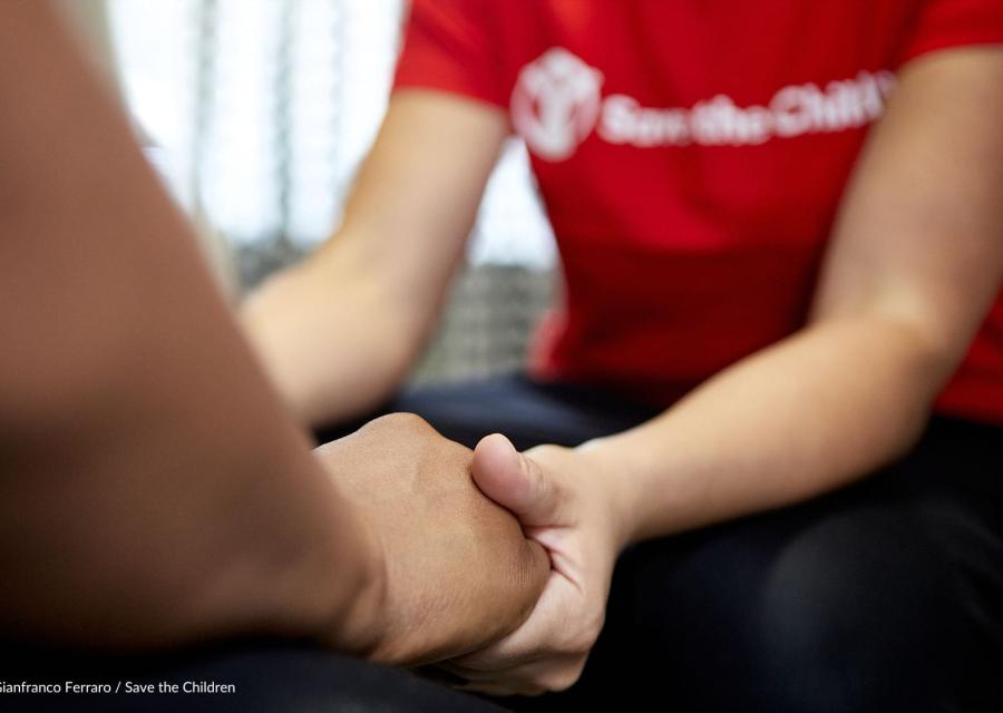 operatrice save the children che tiene le mani ad una persona supportata