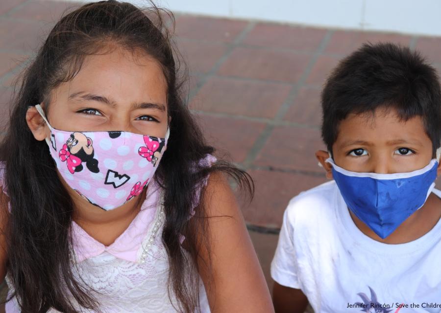 un bimbo e una bambina con mascherine colorate in foto a mezzobusto