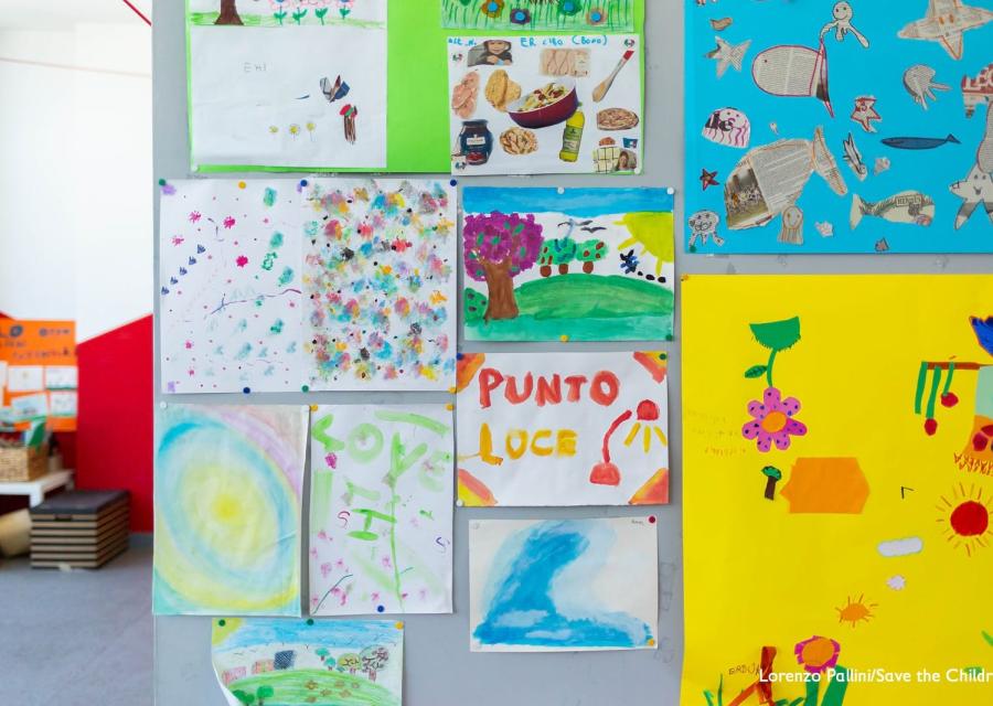 Disegni di bambini attaccati al muro in Punto Luce Save the Children