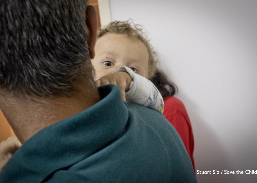 papà di spalle tiene in braccio bambino