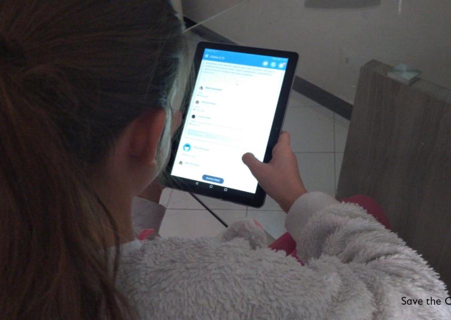 Bambina di spalle con pile bianco che guarda il tablet