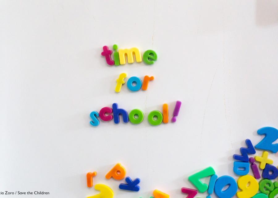 lavagna magnetica bianca con lettere colorate in basso a destra e in centro le lettere formano la scritta time for school