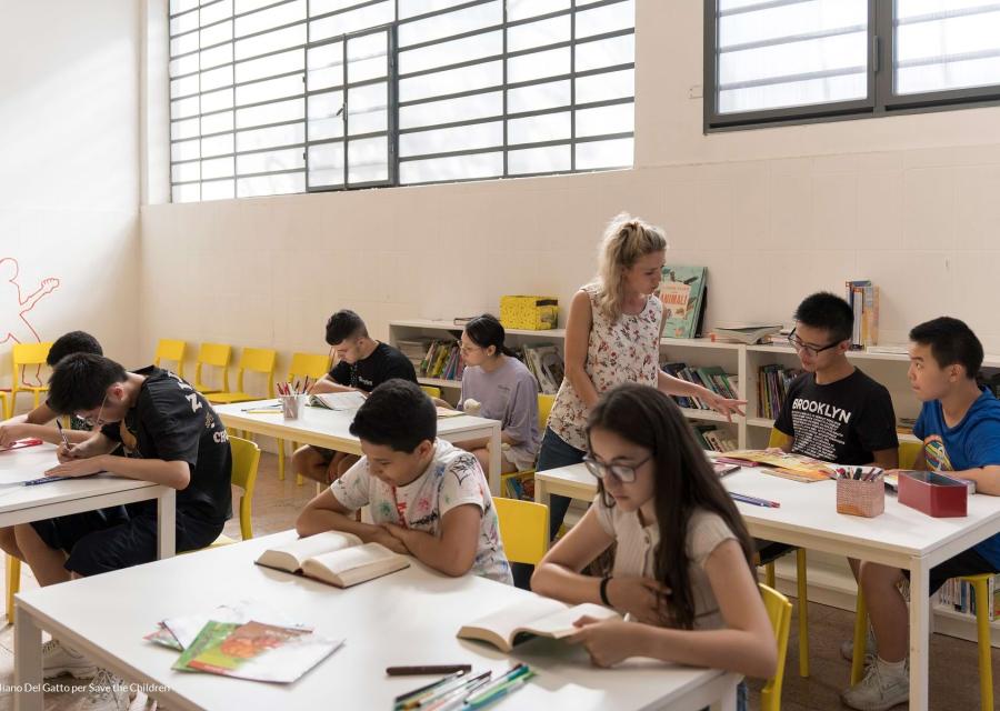 Studenti, studentesse e una insegnante fotografati mentre lavorano in classe