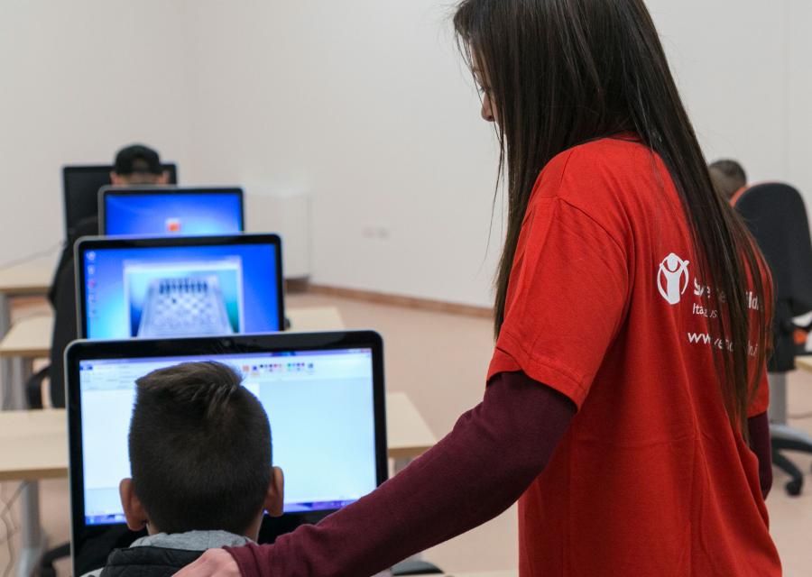 operatrice-mano-sulla-spalla-di-un-bambino-di-spalle-al-computer