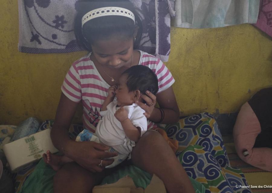 ragazza filippina sfollata tiene in braccio neonato