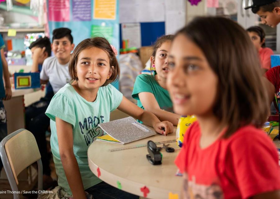 Due bambine in primo piano sedute a una tavolo