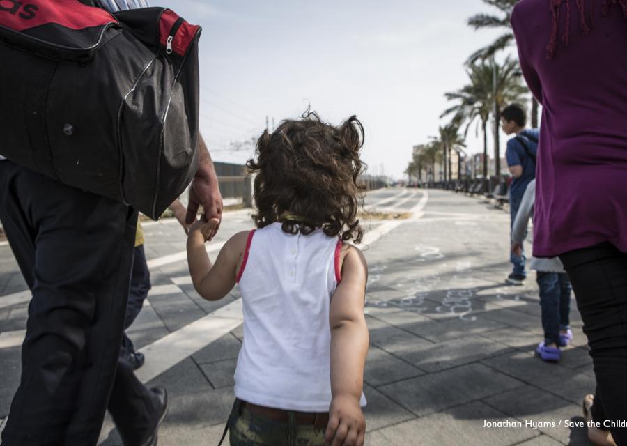 bambina di spalle che cammina mano nella mano con il papà